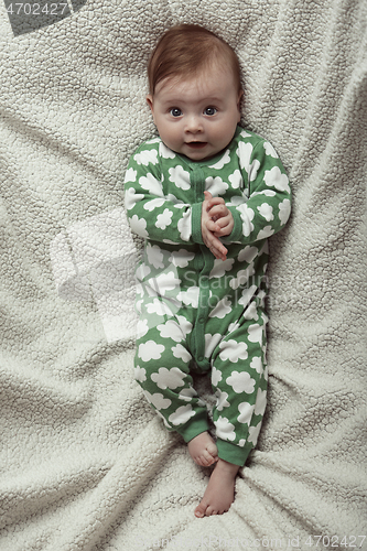 Image of cute little baby playing with hands and smiling