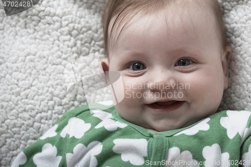 Image of cute little baby playing with hands and smiling