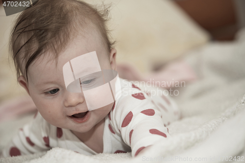 Image of cute little baby playing with hands and smiling