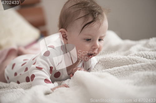 Image of cute little baby playing with hands and smiling