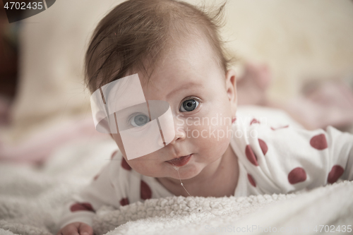 Image of cute little baby playing with hands and smiling