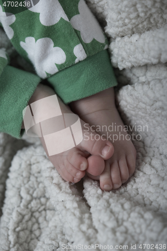 Image of cute little baby playing with hands and smiling