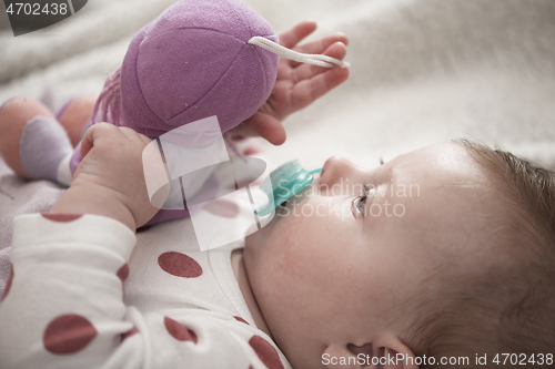 Image of cute little baby playing with hands and smiling