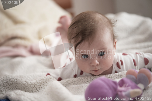 Image of cute little baby playing with hands and smiling