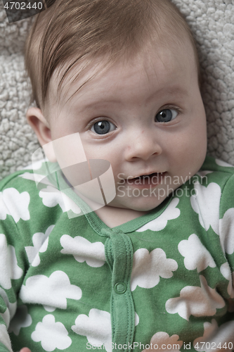 Image of cute little baby playing with hands and smiling