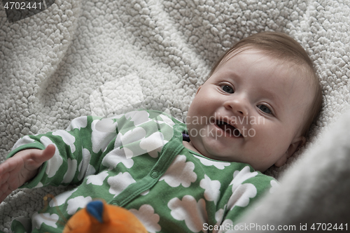 Image of cute little baby playing with hands and smiling