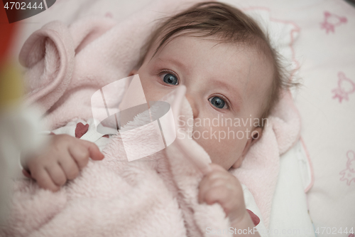 Image of cute little baby playing with hands and smiling