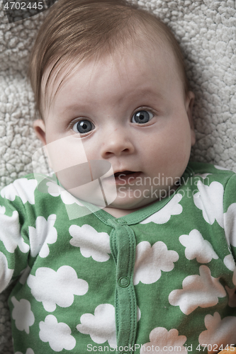 Image of cute little baby playing with hands and smiling
