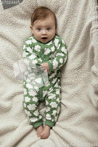 Image of cute little baby playing with hands and smiling