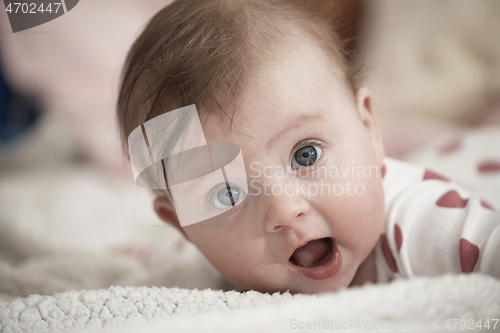 Image of cute little baby playing with hands and smiling