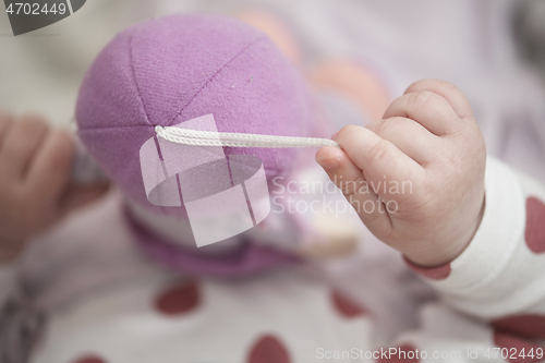 Image of cute little baby playing with hands and smiling