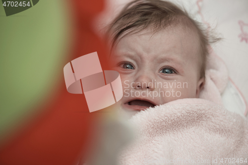 Image of cute little baby playing with hands and smiling