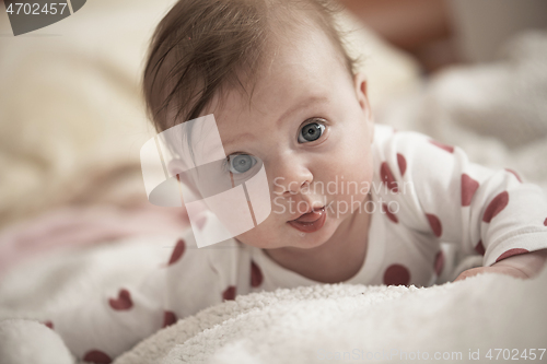 Image of cute little baby playing with hands and smiling