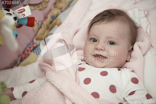 Image of cute little baby playing with hands and smiling