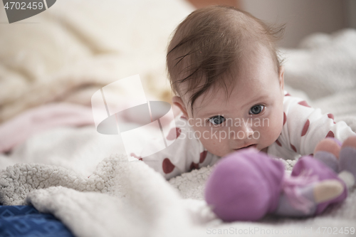 Image of cute little baby playing with hands and smiling