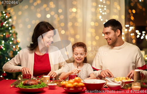 Image of happy family having christmas dinner at home