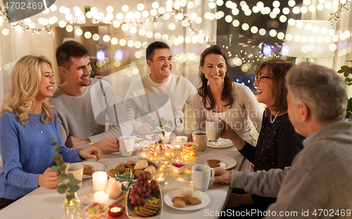 Image of happy family having tea party at home