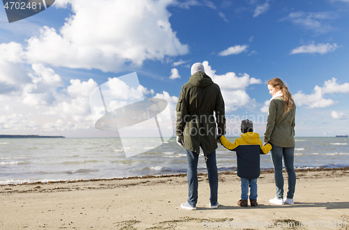 Image of happy family at autumn beach looking at sea