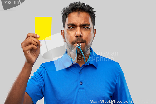 Image of indian referee whistling and showing yellow card