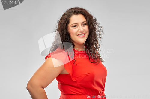 Image of happy woman in red dress over grey background