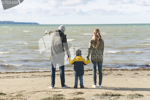 Image of happy family at autumn beach looking at sea