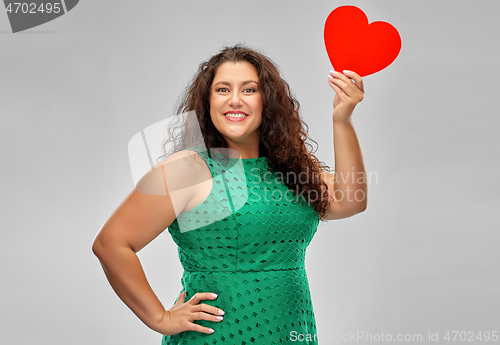 Image of happy woman in green dress holding red heart