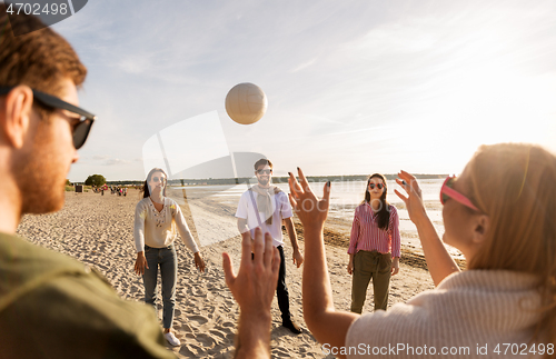 Image of friends playing volleyball on beach in summer