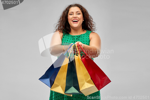 Image of happy woman in green dress with shopping bags