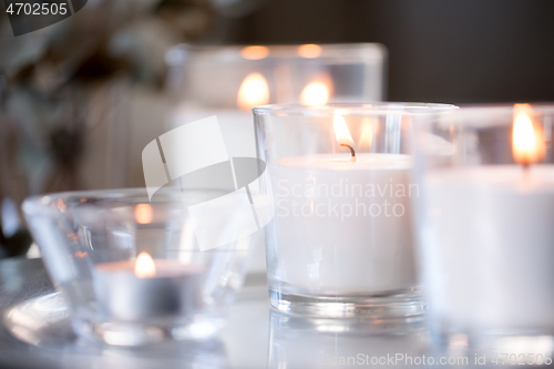 Image of burning white fragrance candles on table