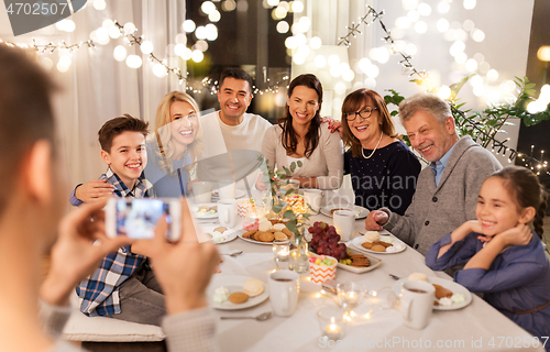 Image of family having dinner party and taking selfie