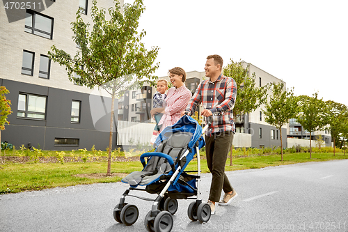 Image of family with baby and stroller walking along city