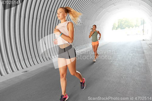 Image of young women or female friends running outdoors