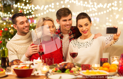 Image of friends taking selfie at christmas dinner