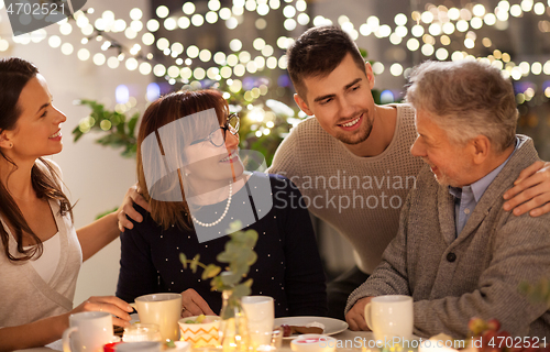 Image of happy family having tea party at home