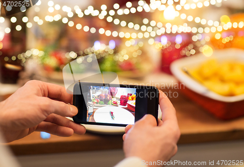 Image of hands photographing food at christmas dinner