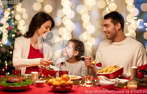 Image of happy family having christmas dinner at home