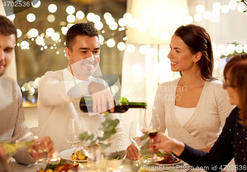 Image of happy family having dinner party at home