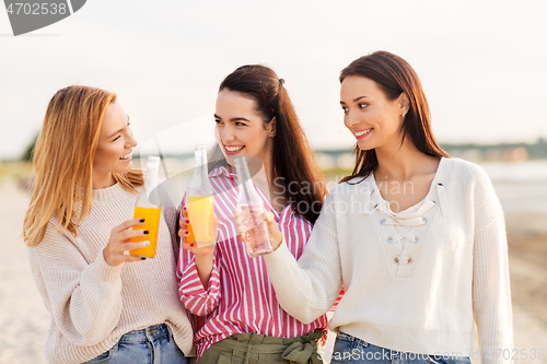 Image of young women toasting non alcoholic drinks on beach