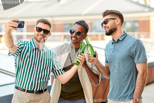 Image of men drinking beer and taking selfie by smartphone