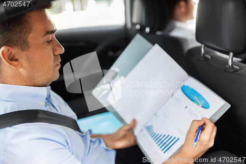 Image of businessman with coffee on car back seat