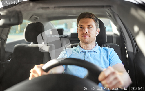 Image of man or driver with wireless earphones driving car