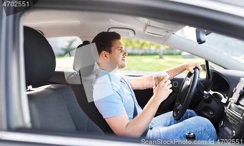 Image of man or driver with takeaway coffee cup driving car