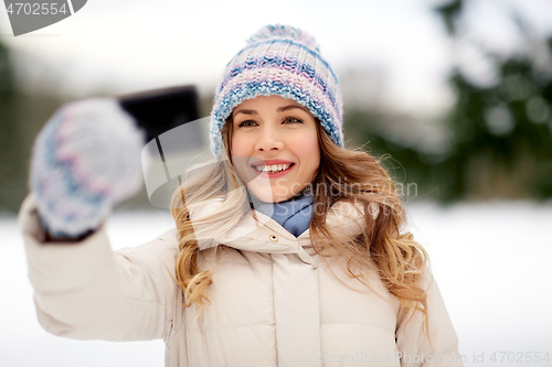 Image of woman taking selfie by smartphone in winter