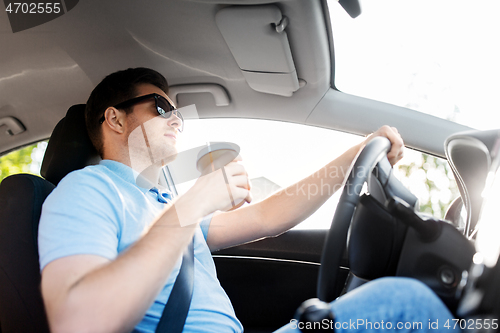 Image of man or driver with takeaway coffee cup driving car