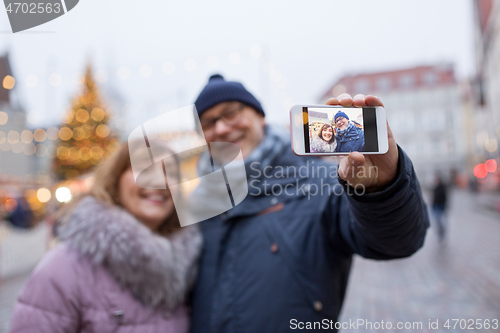 Image of senior couple taking selfie at christmas market