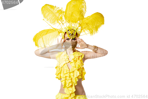 Image of Beautiful young woman in carnival, stylish masquerade costume with feathers dancing on white studio background.