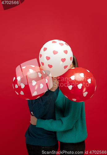 Image of Beautiful couple in love on red studio background. Valentine\'s Day, love and emotions concept