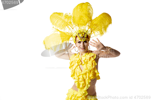 Image of Beautiful young woman in carnival, stylish masquerade costume with feathers dancing on white studio background.