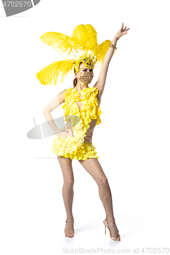 Image of Beautiful young woman in carnival, stylish masquerade costume with feathers dancing on white studio background.