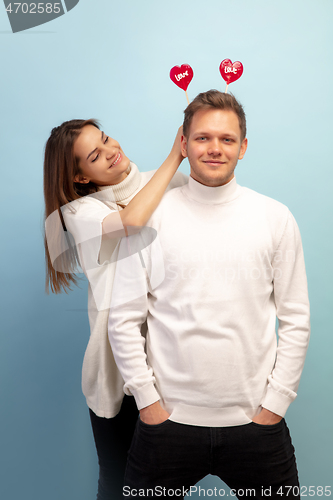 Image of Beautiful couple in love on blue studio background. Valentine\'s Day, love and emotions concept